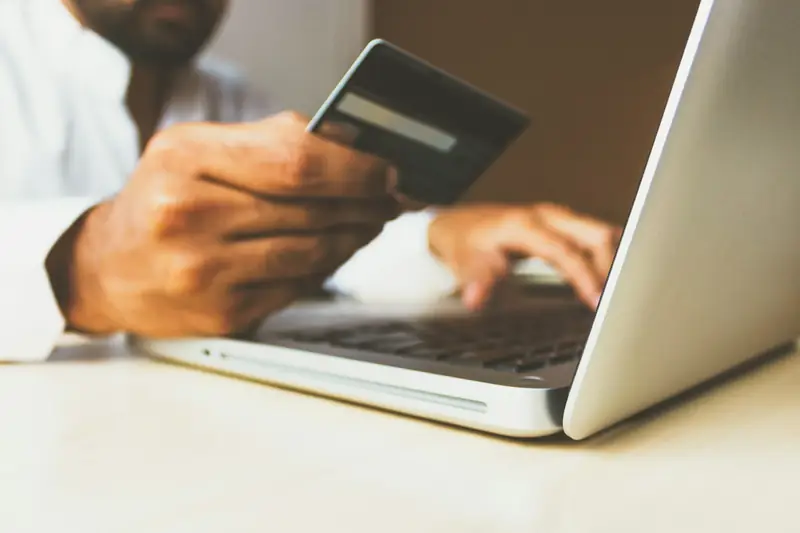 Shopper paying online with a card and laptop